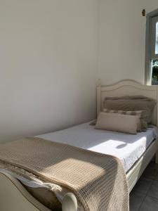 Bett in einem weißen Zimmer mit Tagesdecke in der Unterkunft Nature and Comfort House with Pool 10 people 1h from SP in São Roque + 52 Fotos