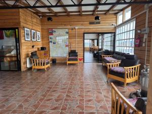 a large room with wooden walls and tables and chairs at El Sendero in Puerto Natales