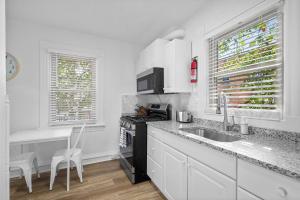 ピッツバーグにあるPittsburgh Shadyside 3B Modern and Cozy Private Bedroom with Shared Bathroomのシンクとコンロのある白いキッチン