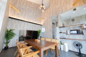a dining room with a wooden table and chairs at Hanare AOZORA in Onna