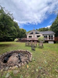 a house with a fire pit in the yard at Le Nørda sur la rivière Vallée Bras du Nord in Saint-Raymond