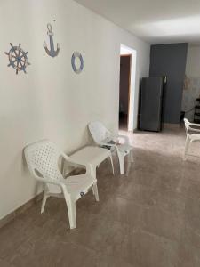 a living room with two chairs and a table at Refugio Marinero in Coveñas