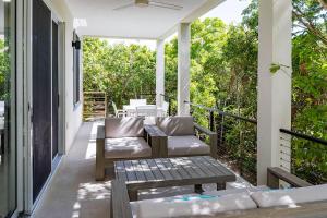 a patio with a couch and chairs on a porch at Wyakha 1 Garden View in Long Bay Hills