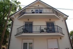 a white building with a balcony on it at Apartments Idila in Bela Crkva