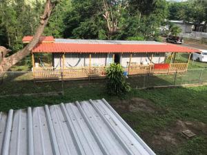 a house with an orange roof in a yard at Casa Nostra Vagón in Coamo