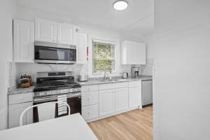 a kitchen with white cabinets and a stove top oven at Pittsburgh Shadyside 3C Bright and Stylish Private Bedroom with Shared Bathroom in Pittsburgh