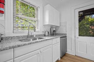 a white kitchen with a sink and a window at Pittsburgh Shadyside 3C Bright and Stylish Private Bedroom with Shared Bathroom in Pittsburgh