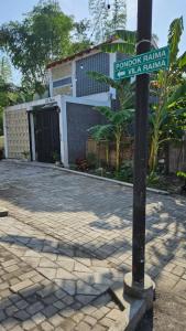 a street sign on a pole in front of a house at Cute Room 1 at Pondok Raima SYARIAH in Gresik