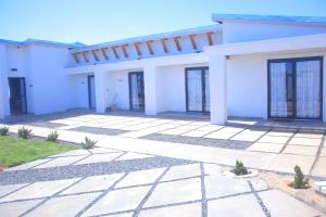 a white house with a lot of windows at Rearabetsoe Guest House in Maputsoe