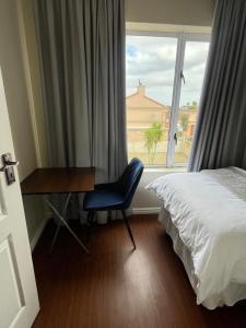 a bedroom with a desk and a bed and a window at Private Rooms - home-stay in Gqeberha
