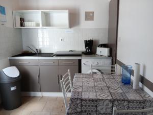 a small kitchen with a table and a sink at Charmante maison au calme près de la plage, jardinet privatif, 4 pers, animaux sur demande - FR-1-476-13 in La Faute-sur-Mer