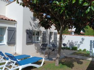a pair of chairs and a tree in front of a house at Charmante maison au calme près de la plage, jardinet privatif, 4 pers, animaux sur demande - FR-1-476-13 in La Faute-sur-Mer