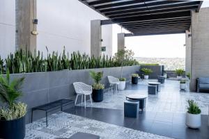 a lobby with tables and chairs and potted plants at LOFT Apartment Downtown Area in Tijuana