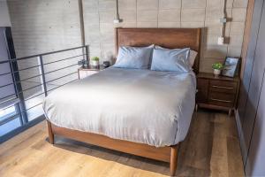 a bedroom with a large bed with a wooden headboard at LOFT Apartment Downtown Area in Tijuana