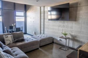 a living room with a couch and a tv at LOFT Apartment Downtown Area in Tijuana