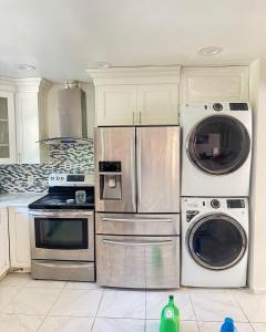 a kitchen with two washers and a stove and a microwave at 3 bedrooms in Deer Park
