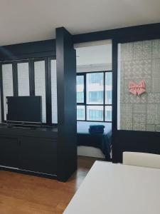 Una sala de estar con un televisor y una cómoda con un lazo rosa. en 02Nice room phuket town near Shopping Malls and Naka night market, en Phuket