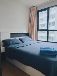 a bed with a blue blanket on it in a bedroom at 02Nice room phuket town near Shopping Malls and Naka night market in Phuket Town +35 photos