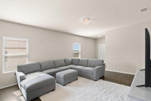 Una sala de estar con un sofá y un televisor. en 5BR Furnished Stay Near Randolph AFB & Hospitals, en Cibolo