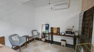 a room with two chairs and a table and a microwave at Pondok Raima SYARIAH with Mini Pool in Giri