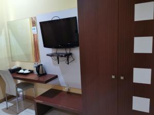 Una habitación con un escritorio y un televisor en la pared. en Mutiara Mansion Aparthotel, en Seminyak