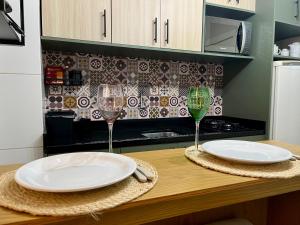 two empty plates and wine glasses on a kitchen counter at ApComplete in the center in Caxias do Sul +31 photos