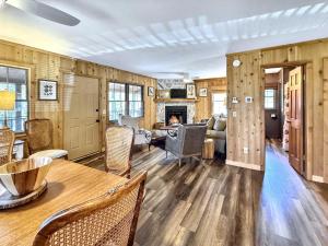 Una sala de estar con mesa y sillas y una chimenea. en The Spotted Owl, en Highlands