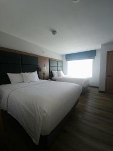 a hotel room with two beds and a window at Wingate by Wyndham Youngstown - Austintown in Youngstown