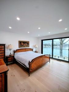 a bedroom with a large bed and a large window at Maison prestige sur la rive in Laval