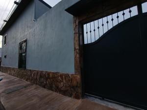 a black garage door on a building with a wooden floor at Casa Kanaph in Reynosa +4 photos