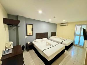 a hotel room with two beds and a television at Seeds Hotel Klang Meru in Klang