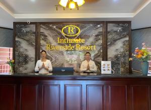 two women sitting at a counter with their hands in prayer at Intimate Riverside Resort Vang Vieng in Vang Vieng +23 photos