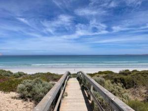 a wooden boardwalk leading to the beach with the ocean at Anchored at Eba in Eba Island