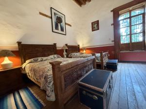 a bedroom with a large wooden bed and a window at Hotel Monumento Hacienda de Amoltepec in Zacatlán