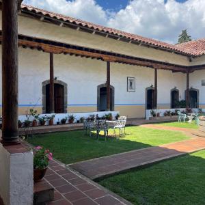 a patio of a house with a table and chairs at Hotel Monumento Hacienda de Amoltepec in Zacatlán