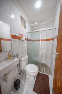 a bathroom with a toilet and a shower and a sink at Casa Queiroz in Porto De Galinhas