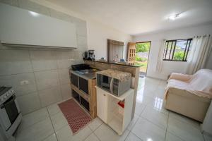 a kitchen with a sink and a microwave at Casa Queiroz in Porto De Galinhas +24 photos