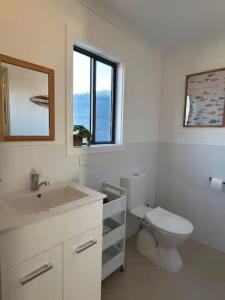 a bathroom with a toilet and a sink and a window at Anchored at Eba in Eba Island +33 photos