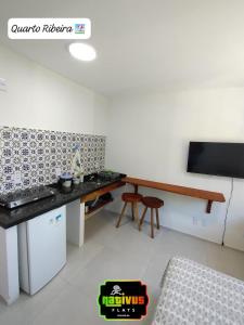 a kitchen with a counter and a table in a room at Nativus Flats in Itacaré