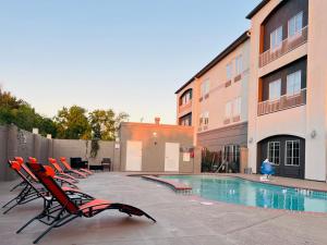 a group of chairs sitting next to a swimming pool at Sonesta Essential North Houston in Houston