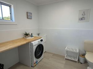 a laundry room with a washing machine in it at Anchored at Eba in Eba Island