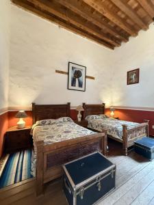 a bedroom with two beds and two tables in it at Hotel Monumento Hacienda de Amoltepec in Zacatlán