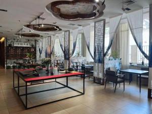 a dining room with tables and chairs and windows at Xian Empress Hotel in Xi'an
