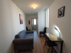 una sala de estar con un sofá y una mesa en Appart T2 wifi Tv Balcon Jardin Parking, en Montélimar