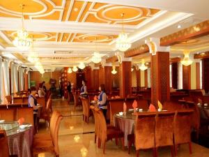 a restaurant with tables and people sitting at them at Dunhuang Dunhe Hotel in Dunhuang