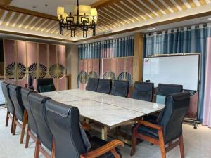 a conference room with a large table and chairs at 7 Days Inn Fucheng Wu Gongci Gaodeng East Street Binjiang Road in Haikou