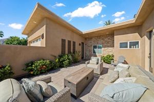 a patio with chairs and a wooden table at Chill-Inn, an Indian Wells Oasis in Indian Wells