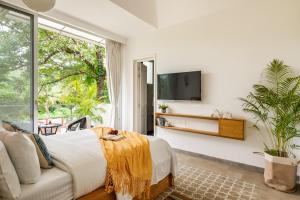 a bedroom with a large bed and a large window at Palette by RÊVE Escapes - Premium 2 BHK apartment Near Anjuna Beach in Assagao