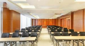 a room with rows of tables and chairs at Jinjiang Inn Select Hohhot Chengjisihan Square Metro Station in Hohhot