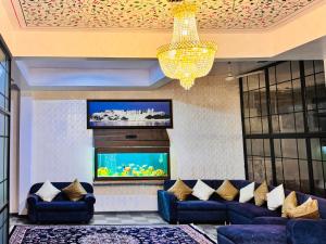 a living room with blue couches and a flat screen tv at Hotel Lake Vista Stays in Udaipur